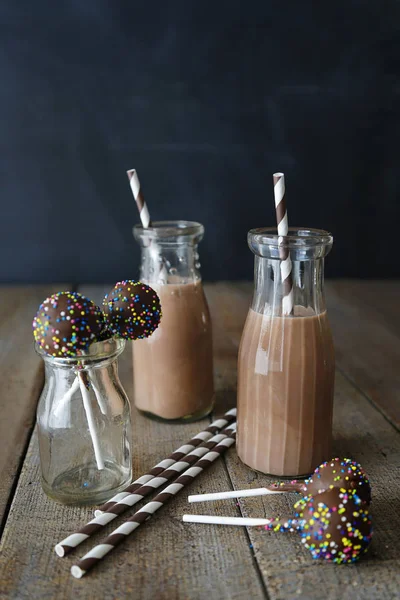 Chocolade melk met cake knalt en rietjes — Stockfoto