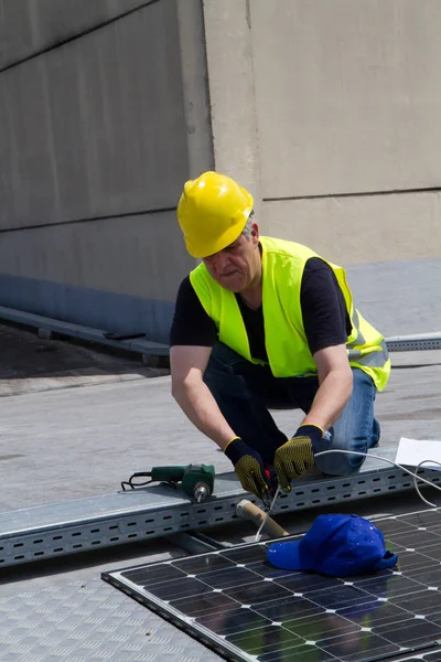 Lavoratori qualificati che lavorano con pannelli fotovoltaici — Foto Stock