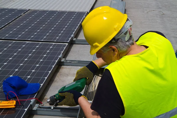 Zkušení workerworking s fotovoltaickými panely — Stock fotografie