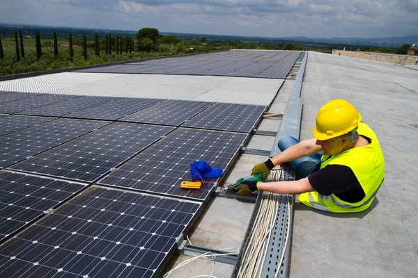 Lavoratori qualificati che lavorano con pannelli fotovoltaici — Foto Stock