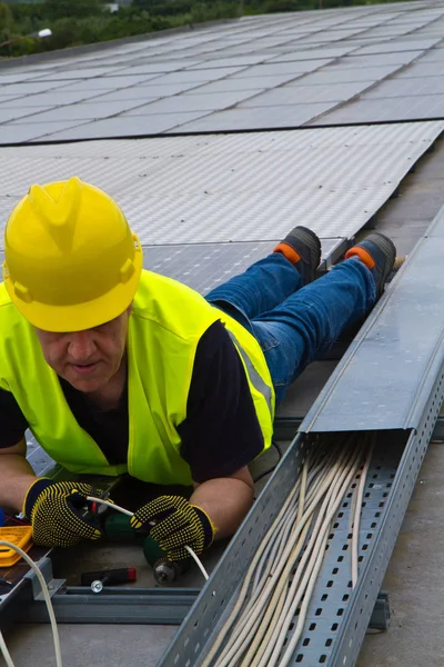 Worke op een dak te passen fotovoltaïsche panelen — Stockfoto