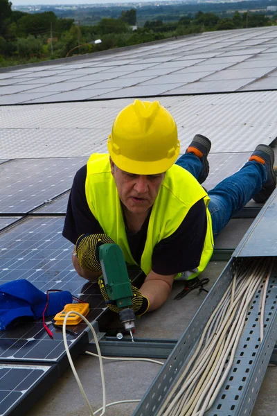 Worke fotovoltaik paneller uyacak bir çatı üzerinde — Stok fotoğraf