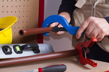 Tesisatçı anda onun tezgah üzerinde boru uyacak