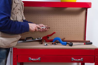 Tesisatçı anda onun tezgah üzerinde boruları tamir