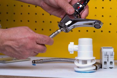 Tesisatçı anda onun tezgah üzerinde boruları tamir