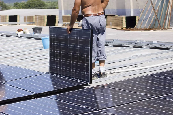 建物の屋根に太陽光発電パネルをフィッティング — ストック写真