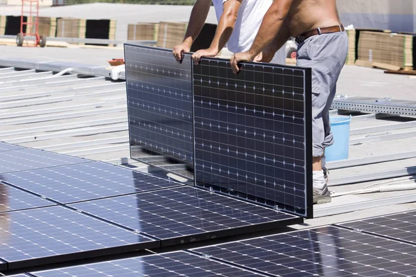 建物の屋根に太陽光発電パネルをフィッティング — ストック写真