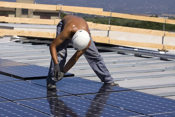 建物の屋根に太陽光発電パネルをフィッティング — ストック写真