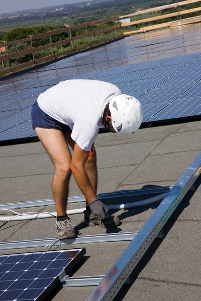 建物の屋根に太陽光発電パネルをフィッティング — ストック写真