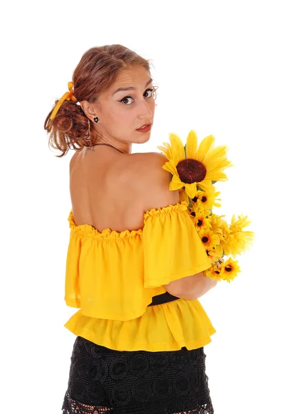 Frau mit Sonnenblumen schaut über die Schulter. — Stockfoto