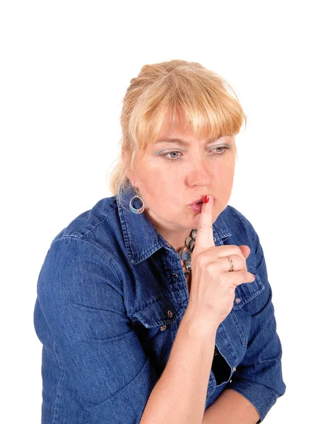Closeup of blond woman with finger over mouth. — Stock Photo, Image