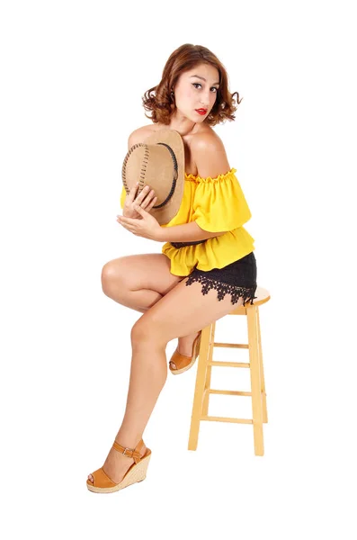 Woman sitting in shorts and hat. — Stock Photo, Image