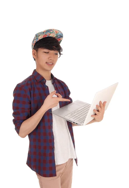 Asian teenager pointing at his laptop. — Stock Photo, Image