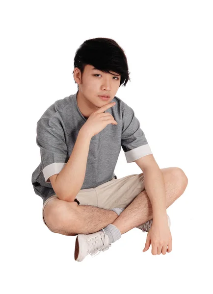Junger asiatischer Mann sitzt auf dem Boden. — Stockfoto