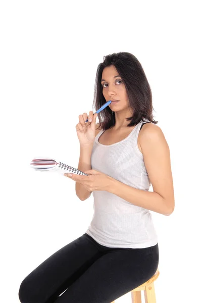 Kvinnan pratar nots med penna i munnen. — Stockfoto