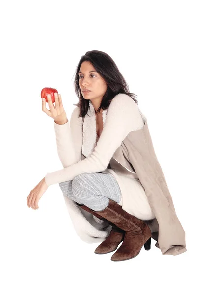 Donna accovacciata guardando una mela rossa . — Foto Stock