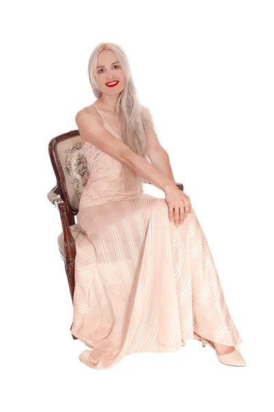 Splendida donna bionda in un abito rosa seduta — Foto Stock
