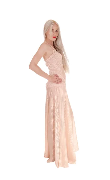 Frau im langen rosafarbenen Kleid stehend — Stockfoto