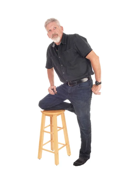 Middle aged man kneeling on chair — Stock Photo, Image