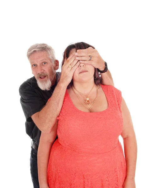 Homem segura as mãos sobre os olhos da esposa — Fotografia de Stock