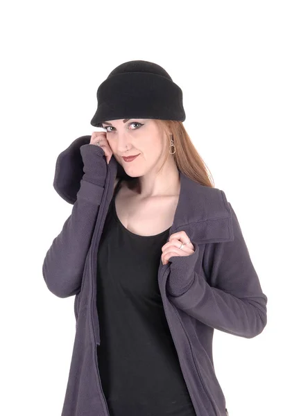 Молодая женщина стоит в зимнем пальто и шляпе — стоковое фото