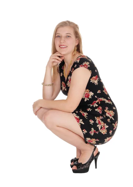Красивая молодая женщина в платье приседает — стоковое фото