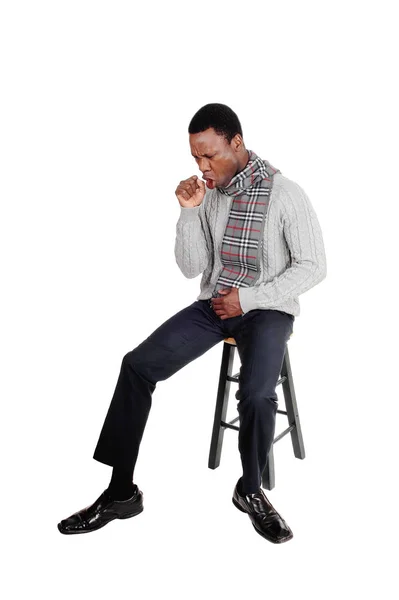 Coughing young African man sitting on chair — Stock Photo, Image