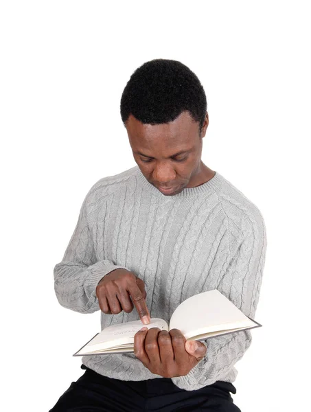 African man sitting and reading his book Stock Photo