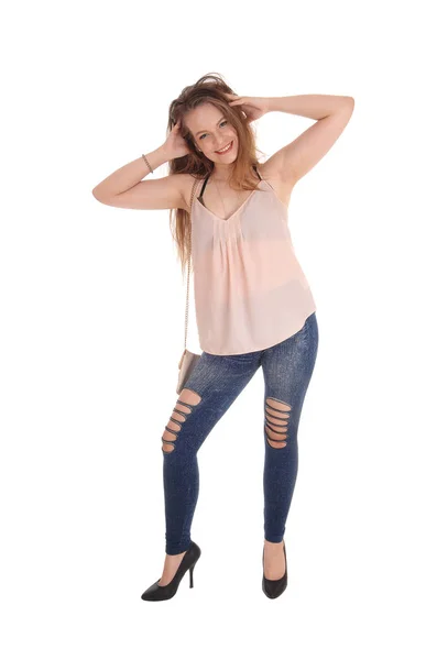 Young woman standing with her hands in her hair — Stock Photo, Image