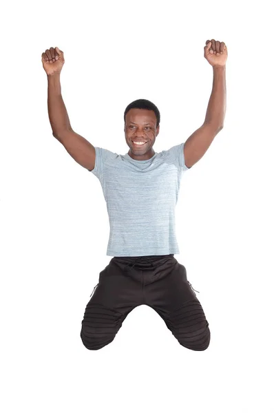 Glücklicher afrikanischer Mann mit kniendem Blick nach oben — Stockfoto