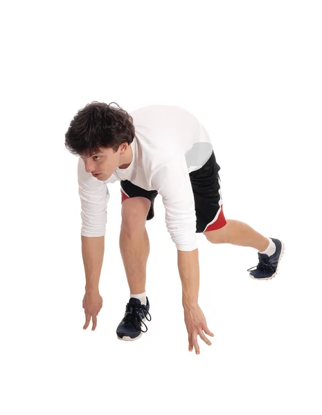 Junger Mann in der Startposition für einen Lauf — Stockfoto