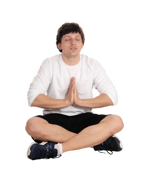 Young man sitting on floor meditating in yoga — Stock Photo, Image
