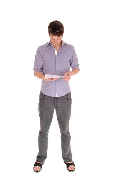 Young Caucasian man standing and reading — Stock Photo, Image