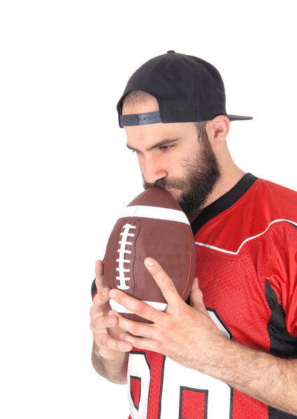 Football player holding his ball on his mouth, thinking