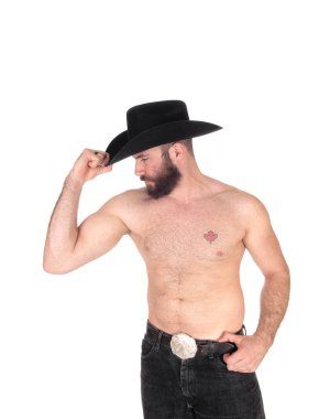 Gömleksiz adam uzakta bakan bir kovboy şapkası ile