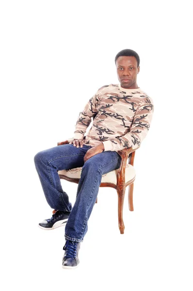 Африканский мужчина сидит на стуле и расслабляется — стоковое фото