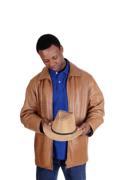 Homem bonito em jaqueta de couro marrom segurando seu chapéu — Fotografia de Stock