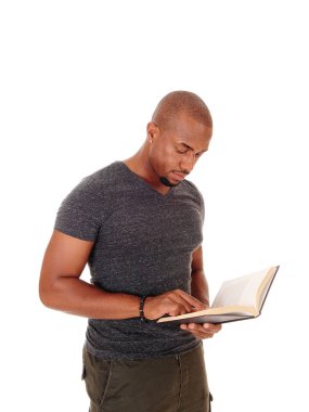Afrikalı adam ayakta, kitabını okuyor.