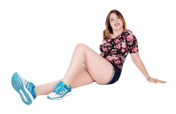 Lovely young woman sitting on floor in jeans shorts — Stock Photo, Image