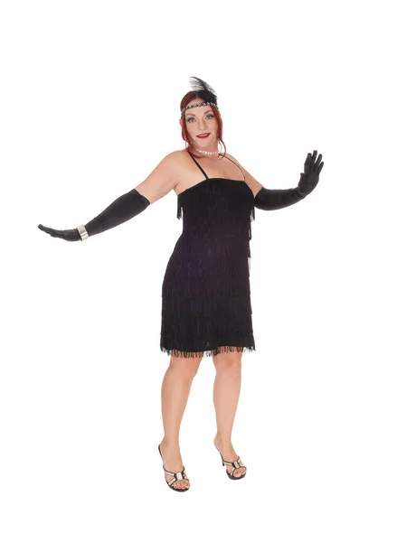 Kobieta stojąca w czarnej sukience i długich goździkach — Zdjęcie stockowe