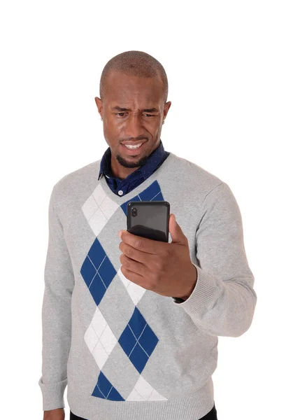 Hombre africano mirando perplejo a su teléfono celular — Foto de Stock