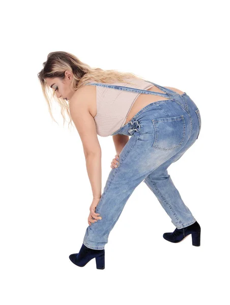 Jovem mulher curvando-se para baixo em suas calças jeans — Fotografia de Stock