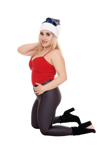 Frau kniet in rotem Top und blauem Weihnachtsmann-Hut — Stockfoto