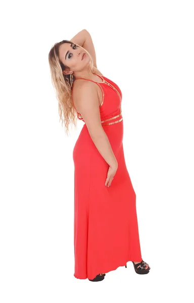 Mooie blonde vrouw staan in rode jurk in profiel — Stockfoto