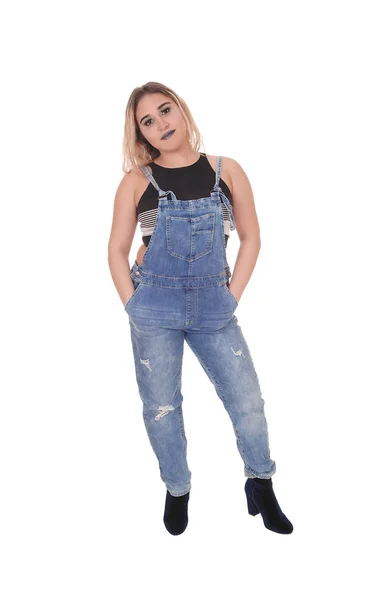 Ung kvinna i arbetsjeans stående i ateljén — Stockfoto