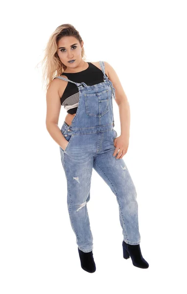 Ung kvinna i arbetsjeans stående i ateljén — Stockfoto