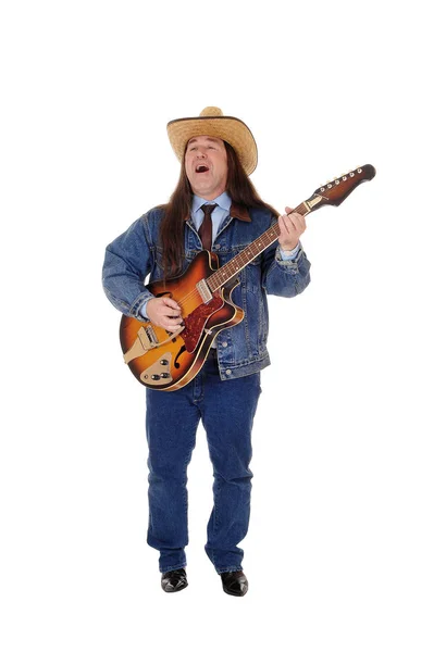 Мужчина средних лет, играющий на гитаре и поющий — стоковое фото