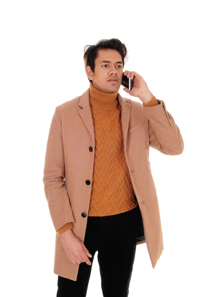Mladý muž mluví na mobilu v kabátě — Stock fotografie