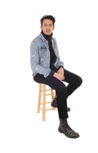 Tall young man sitting on a bar chair in a jacket — 스톡 사진