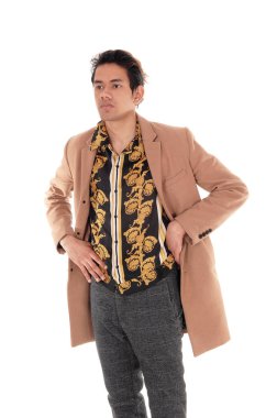 Stüdyoda bej ceketiyle duran genç adam.